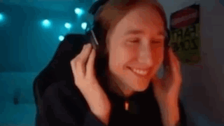 a woman is wearing headphones and smiling while sitting in front of a computer screen .