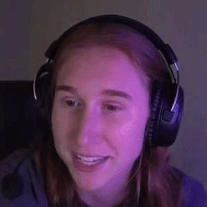 a woman is wearing headphones and smiling while sitting in front of a computer screen .