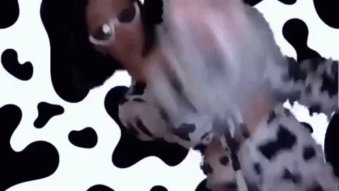 A Woman Is Wearing Sunglasses And A Cow Print Dress . GIF