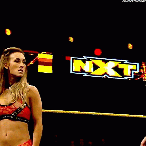 a woman is wrestling a man in a wrestling ring with a w logo in the background .