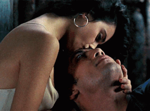 A Woman Kisses A Man On The Forehead In A Close Up GIF