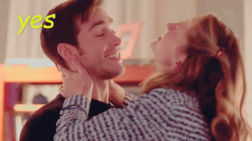 A Woman Kisses A Man On The Forehead With The Word Yes Behind Them GIF