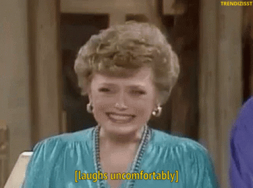 A Woman Laughs Uncomfortably While Wearing A Blue Shirt GIF