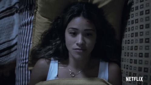 a woman laying in bed with a netflix logo on the bottom