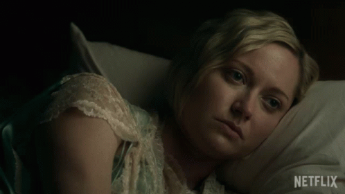 A Woman Laying In Bed With A Netflix Logo On The Bottom Right GIF