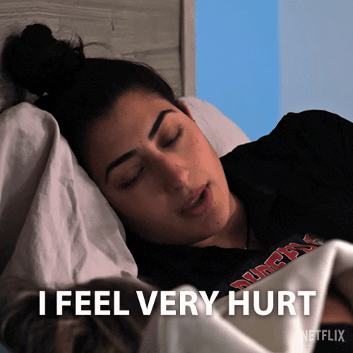 A Woman Laying In Bed With The Words " I Feel Very Hurt " On The Bottom GIF