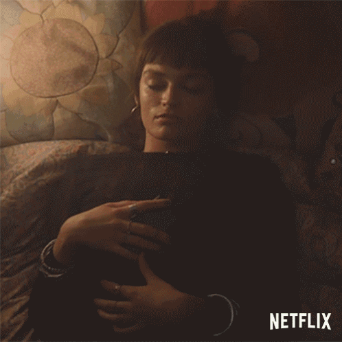 A Woman Laying On A Bed With A Netflix Logo On The Bottom GIF