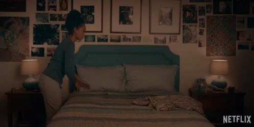 A Woman Laying On A Bed With A Netflix Logo On The Bottom Right GIF