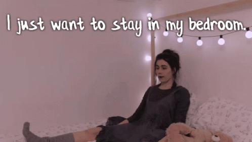 A Woman Laying On A Bed With The Words I Just Want To Stay In My Bedroom GIF