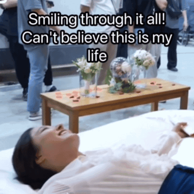A Woman Laying On A Bed With The Words Smiling Through It All Can 'T Believe This Is My Life Above Her GIF