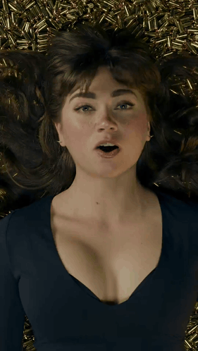 A Woman Laying On A Pile Of Bullets With Her Mouth Wide Open GIF