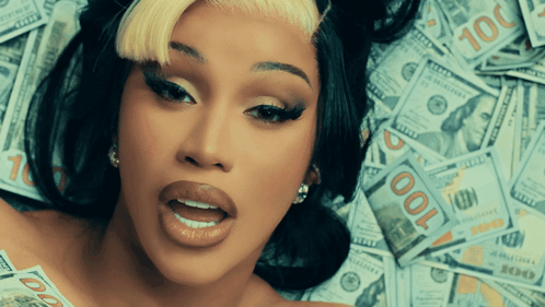 A Woman Laying On Top Of A Pile Of 100 Dollar Bills GIF