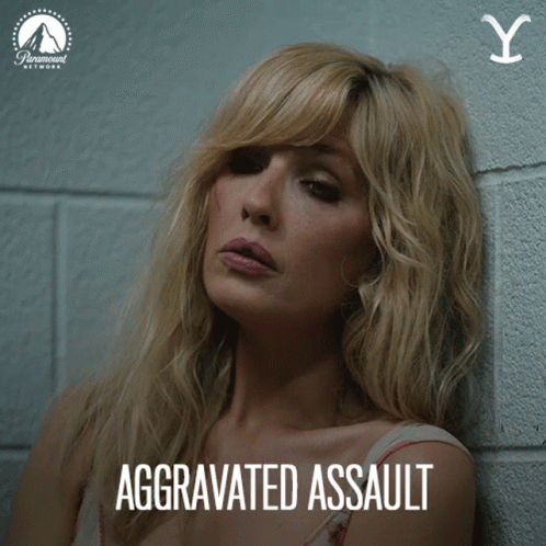 A Woman Leaning Against A Wall With Aggravated Assault Written On The Bottom GIF