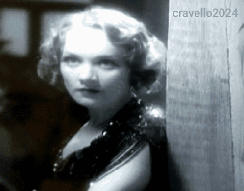 A Woman Leaning Against A Wall With The Year 2024 On The Bottom Right GIF