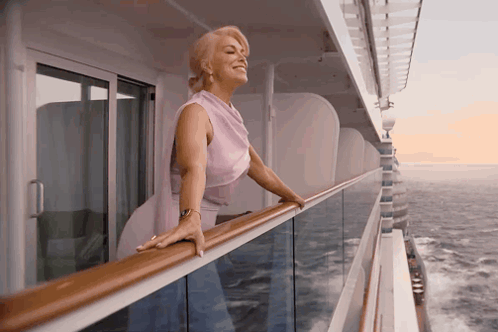 a woman leaning on a railing looking out over the ocean