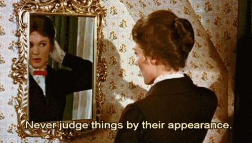 A Woman Looking At Her Reflection In A Mirror With The Words " Never Judge Things By Their Appearance " Below Her GIF