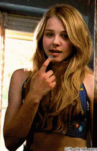 A Woman Looking At Herself In A Mirror With Gifs-Planet.com At The Bottom Of The Image GIF