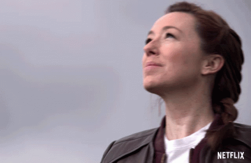 A Woman Looking Up With A Netflix Logo In The Background GIF