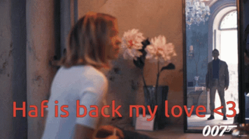 A Woman Looks At Her Reflection In A Mirror With The Words Haf Is Back My Love < 3 GIF