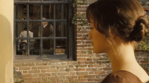 A Woman Looks Out Of A Window At A Man In A Suit GIF
