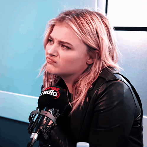 A Woman Making A Face Behind A Microphone That Says Fox Radio GIF
