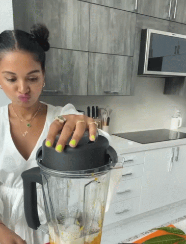 A Woman Making A Face While Holding A Blender GIF