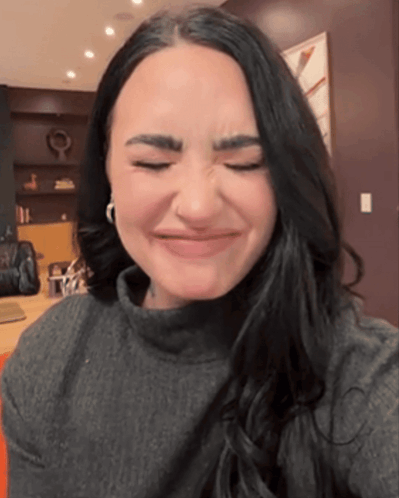 A Woman Making A Face With Her Eyes Closed GIF
