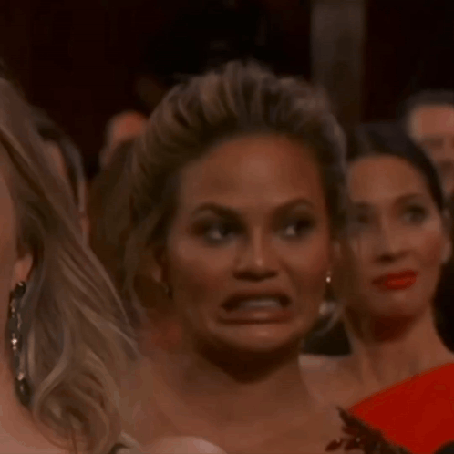 A Woman Making A Funny Face In A Crowd GIF