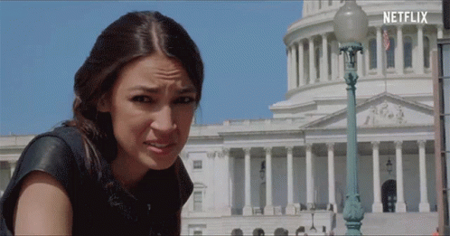 A Woman Making A Funny Face In Front Of A Building With Netflix Written On The Bottom GIF