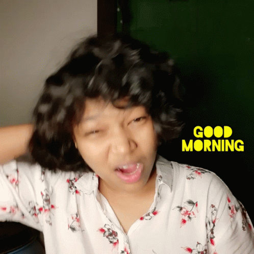 A Woman Making A Funny Face In Front Of A Good Morning Sign GIF