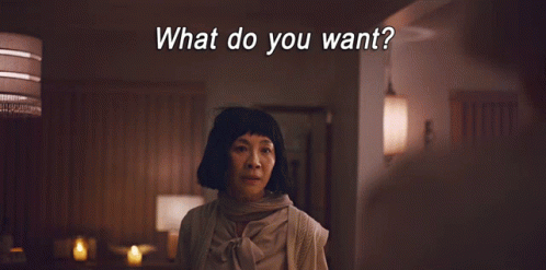 A Woman Making A Peace Sign With The Words What Do You Want Behind Her GIF