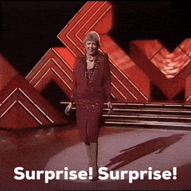 A Woman On A Stage With The Words Surprise Surprise GIF