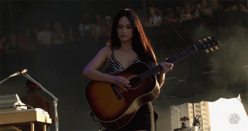 A Woman Playing A Guitar With A Yamaha Logo On It GIF