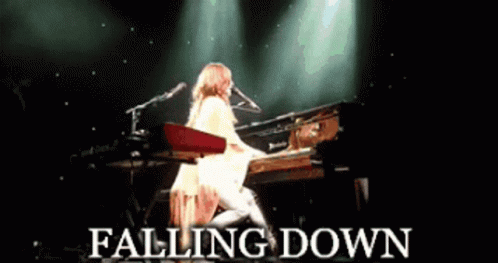 A Woman Playing A Piano With The Words Falling Down Written Below Her GIF
