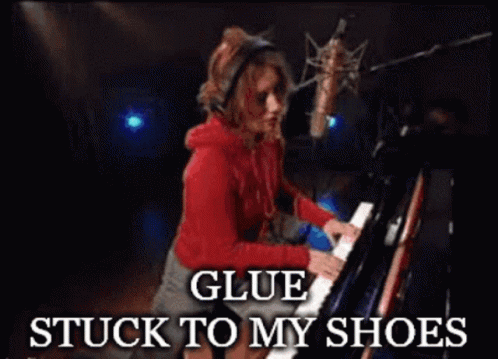 a woman playing a piano with the words glue stuck to my shoes below her