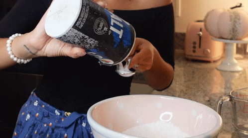A Woman Pours Salt Into A Bowl Of Flour GIF