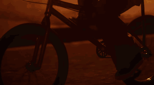 A Woman Riding A Bike In Front Of A Sign That Says ' E ' On It GIF