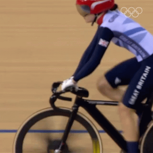 A Woman Riding A Bike With The Word Great Britain On Her Shorts GIF