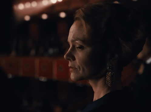 A Woman 'S Face Is Shown In A Dark Room With A Sign That Says ' A ' On It GIF