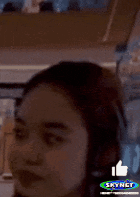 A Woman 'S Face Is Shown With A Skynet Logo In The Background GIF
