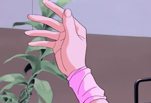 A Woman 'S Hand In A Pink Sweater Is Reaching Out Towards A Plant GIF
