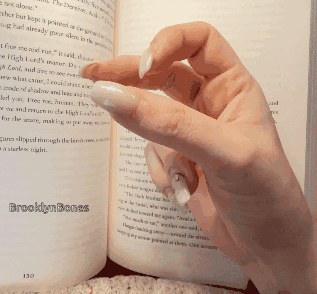 A Woman 'S Hand Is Holding A Book Open To A Page That Says Brooklynbones On It GIF