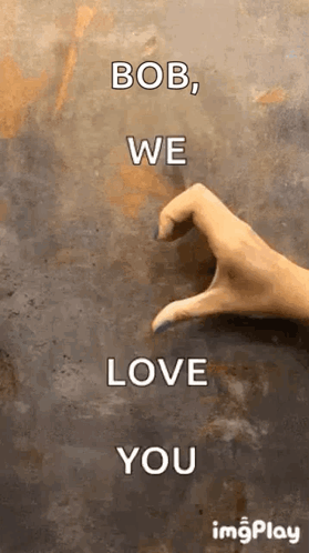 A Woman 'S Hand Is Making A Heart Shape With Her Fingers On A Wall . GIF