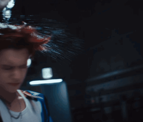 A Woman 'S Head Is Being Sprayed With Water In The Dark GIF