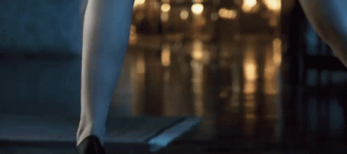 A Woman 'S Legs Are Shown In Front Of A Blurry Background Of Lights GIF