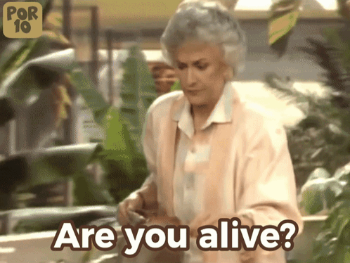 A Woman Says " Are You Alive " In Front Of Plants GIF