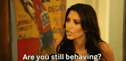 A Woman Says " Are You Still Behaving " In Front Of A Poster That Says Jenner Wins It All GIF