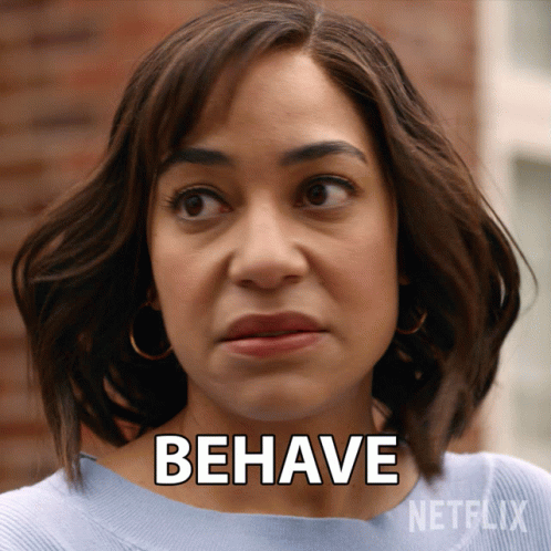 A Woman Says " Behave " In Front Of A Netflix Advertisement GIF