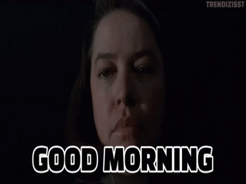 A Woman Says Good Morning In Front Of A Dark Background GIF
