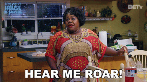A Woman Says Hear Me Roar While Sitting At A Table GIF